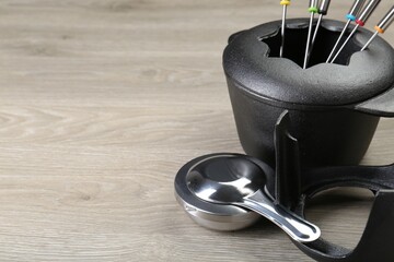 Fondue set on wooden table, space for text