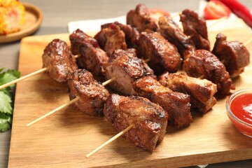 Skewers with delicious shish kebabs on table, closeup