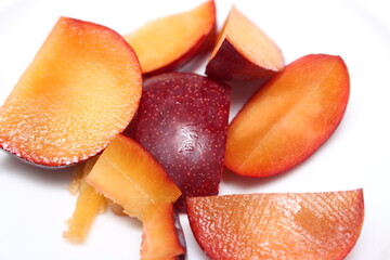 fruit on white background. fruit on a plate. plum pieces ready for snack. fruit with selective focus. fruit details.