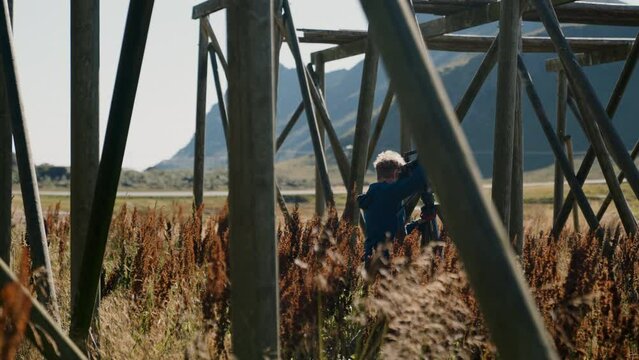 Filmmaker Carries His Camera Near Curly Dock
