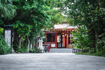 Entrance to a red temple surrounded by greenery