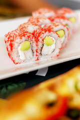 Close-up of red Philadelphia sushi rolls with eel on a blurred background, in a cozy restaurant. Japanese cuisine. Food, fast food, cafes