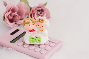 Fototapeta na wymiar 花嫁花婿と計算機　結婚費用　結婚資金　結婚に関わるお金のイメージ写真