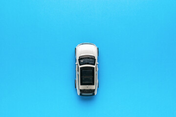 Top view of a white car on a light blue background.