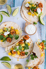 Homemade spicy shrimp tacos with lime and cilantro, ready for eating.