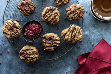 A vintage cooling rack topped with homemade chocolate drizzled lace cookies.
