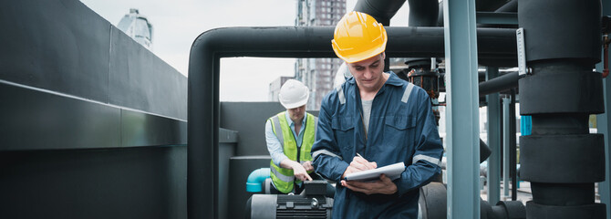 Engineer and team examining the air conditioning cooling system of a huge building or industrial...