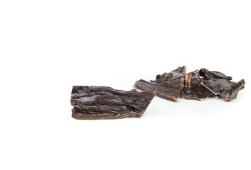 Dehydrated beef liver with defocused pile. Dog treats and snack. Large black dry organ meat. Healthy single ingredient protein rich on minerals and vitamins for puppies and dogs. Selective focus.