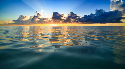 Sunset on sea. Beach sunrise with cloudy sky.