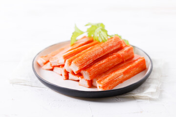 Crab sticks on white plate.