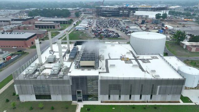 Industrial building. Aerial perspective of the Henry Ford campus: prominent buildings, vast parking, and a distinctive storage tank. A testament to Ford's enduring heritage.