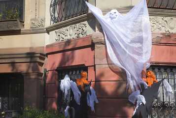 seasonal halloween ghost decorations adorning a townhouse home