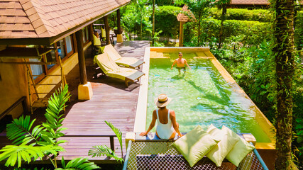 Modern house with a swimming pool, modern pool villa at the beach, luxury villa in Thailand, a couple of men and woman on a luxury vacation in Thailand relaxing in the swimming pool of a pool villa