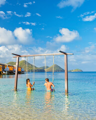 A Couple playing on a swing on the beach of the tropical Island Saint Lucia or St Lucia Caribbean,...