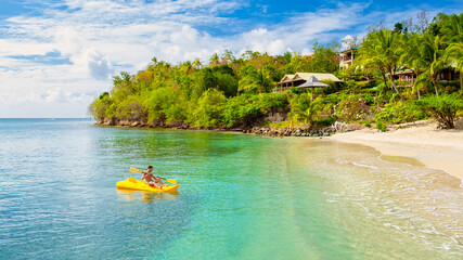 young men in a kayak on a tropical island in the Caribbean Sea, St Lucia or Saint Lucia. young man...