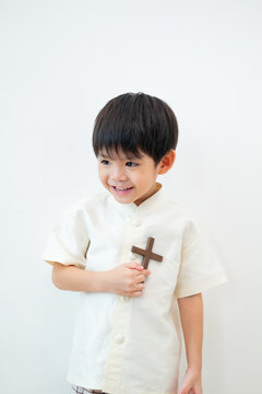 Little Asian boy praying with holding the cross, Christian concept
