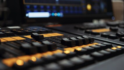 Two faders of a professional dmx lighting control desk console panel being turned down, dimming lights. Light console used in film or tv production, broadcast or live music event production