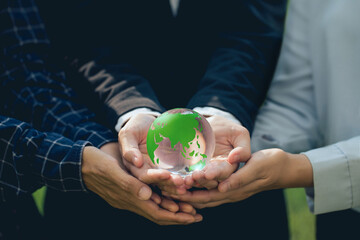 World Environment Day.Corporate social responsibility CSR. Group of business hands holding Globe Glass for Responsibility for the Environment.Ecosystem and Organization Development Cooperation.ESG