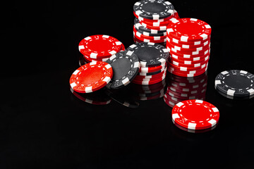 Red and black poker chips on black background