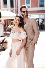 Beautiful fashion woman and her handsome elegant boyfriend in white shirt. Sexy model in summer clothes. Fashionable smiling couple posing in street Europe. Brutal man and female. In sunglasses