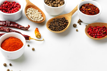 Composition with different aromatic spices in bowls and wooden spoons on white background