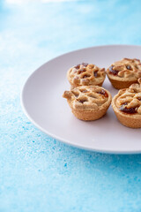 tiny apple pies on pink plate in macro shot
