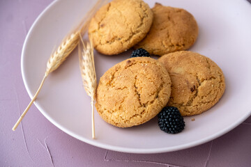 plain wheat grain cookies and raspberries on pink plate