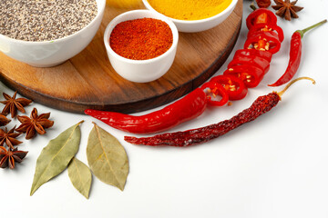 Bowls with spices on wooden board on white background