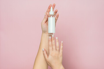 Cosmetic bottle in woman's hands. Cosmetic product branding mockup. Daily skincare and body care routine.