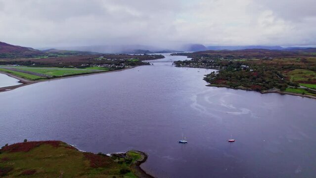 Aerial shot reversing away from the Falls of Lora and bridge in Scottish Highlands near Oban.
