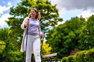 Nordic walking - woman exercising in city park
