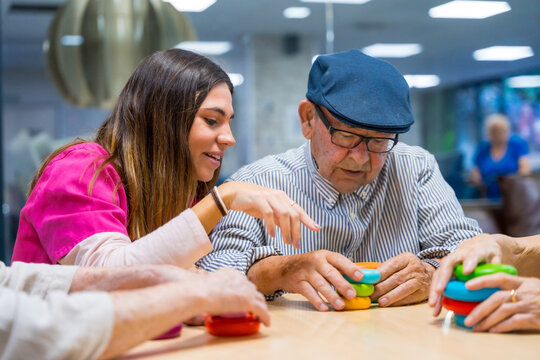 Nurse advising a elder man playing skill games