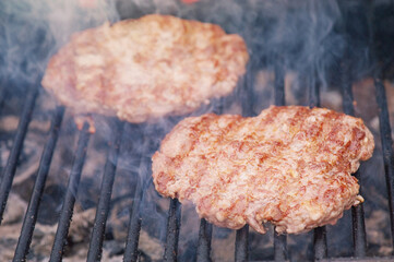 Two meat cutlets are grilled. Food preparation process. Cutlets for a burger.
