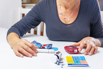 Home health prevention. concept. Woman is preparing device for measuring blood sugar level on the table.  