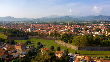 Aerial view of Lucca, Italy. It is a city and comune in Tuscany. The historic centre, full of ancient structures from various eras, is surrounded by sixteenth-century walls. - obrazy, fototapety, plakaty