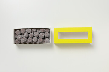 Chocolate candies in box on white background, top view