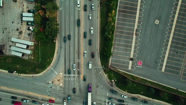 Purple dry van reefer CDL truck driver driving through intersection.Aerial shot of diverse trucks navigating city roads, highlighting the essential role of freight transport in urban settings.Chicago