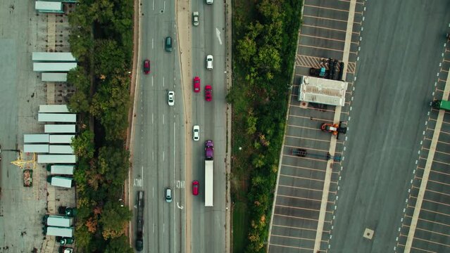 Top down aerial following a purple semi tractor with a white trailer. CDL truck driver on busy road. Empty car hauler non cdl driving the other way. Chicago Illinois