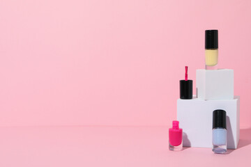 Multicolored nail polishes with white wooden cubes