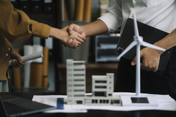 Engineering people and contractor wearing safety helmet on construction site holding blueprint in his hand.