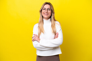Young Uruguayan woman isolated on yellow background keeping the arms crossed in frontal position
