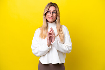 Young Uruguayan woman isolated on yellow background scheming something - obrazy, fototapety, plakaty