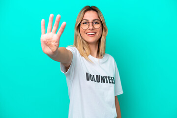 Young volunteer Uruguayan woman isolated on blue background happy and counting four with fingers