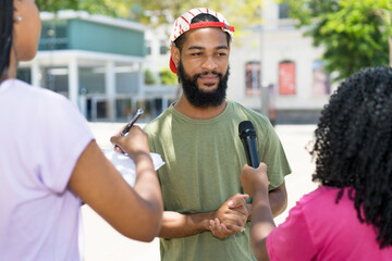 Group of journalists asking famous african american hipster person - obrazy, fototapety, plakaty