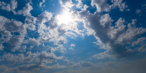 sparkle sun on blue cloudy sky background