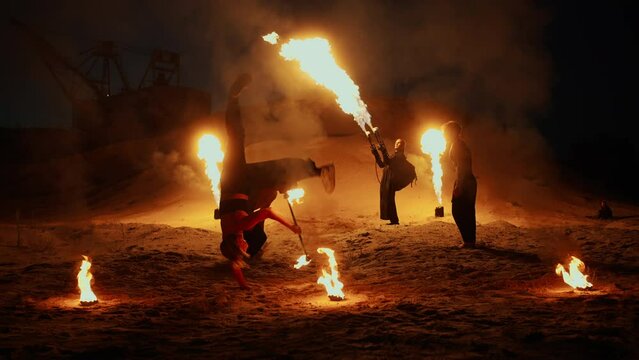 Group Of Stuntmen Performing Amazing Fire Shot Outdoors In Night, Acrobat Woman Performing Tricks
