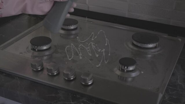close-up of female hands in protective gloves washing a gas stove with a cleaning product video s-log