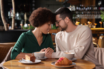 International dating. Lovely couple spending time together in cafe