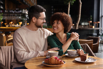 International dating. Lovely couple spending time together in cafe