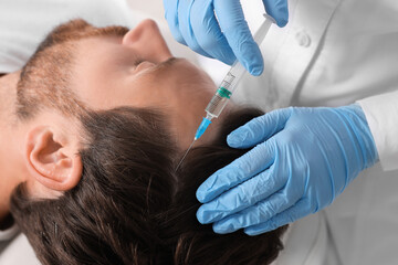 Trichologist giving injection to patient in clinic, closeup
